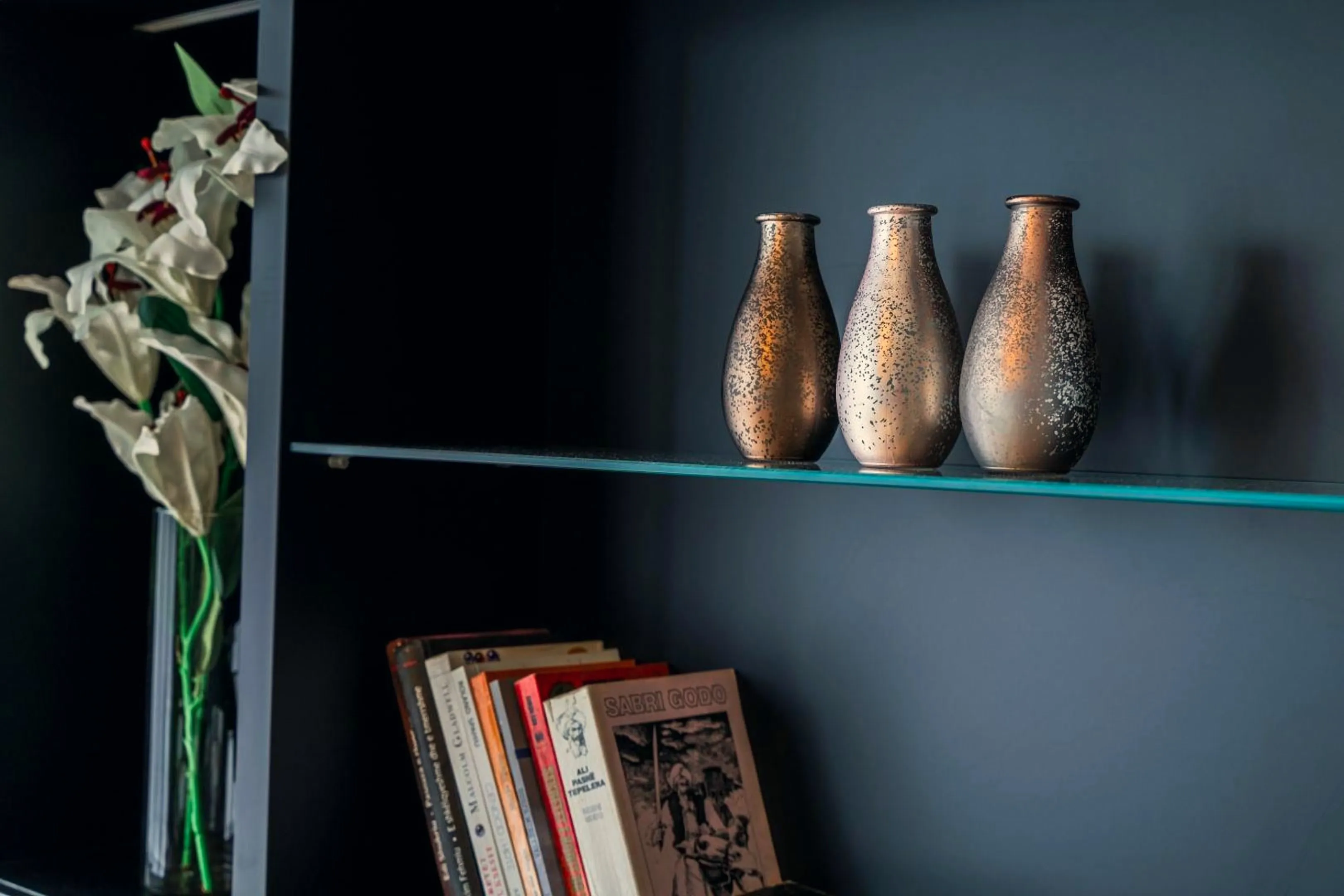 Bronze vases and books on the living-room shelf